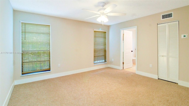 unfurnished bedroom featuring visible vents, ensuite bathroom, a closet, carpet floors, and baseboards