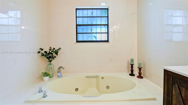 full bath with vanity, tile walls, and a jetted tub