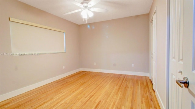 unfurnished room with baseboards, light wood-style floors, and a ceiling fan