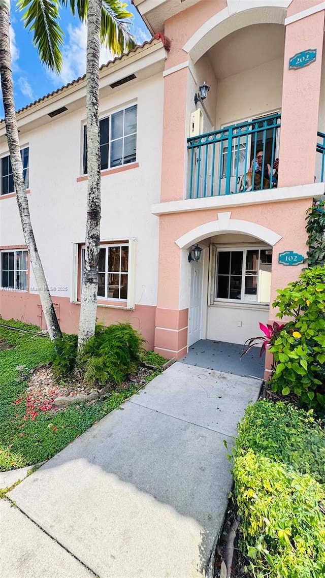 1260 SE 31st Ct Unit 102-34, Homestead, FL 33035 - exterior space with a tiled roof, stucco siding, and a balcony