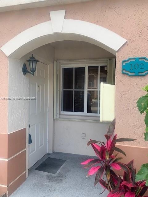 doorway to property with stucco siding