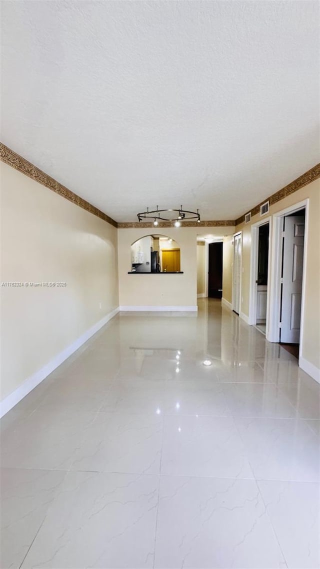 1260 SE 31st Ct Unit 102-34, Homestead, FL 33035 - unfurnished living room featuring baseboards, track lighting, a textured ceiling, visible vents, and marble finish floor