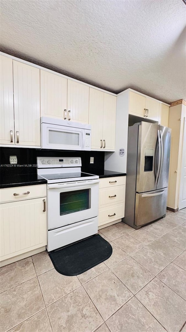 1260 SE 31st Ct Unit 102-34, Homestead, FL 33035 - kitchen featuring white appliances, a textured ceiling, light tile patterned floors, and dark countertops