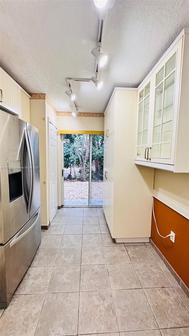 1260 SE 31st Ct Unit 102-34, Homestead, FL 33035 - kitchen featuring glass insert cabinets, a textured ceiling, light tile patterned flooring, light countertops, and stainless steel fridge