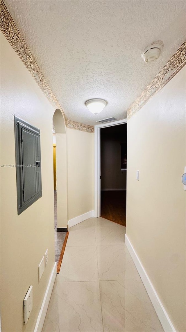 1260 SE 31st Ct Unit 102-34, Homestead, FL 33035 - hallway with baseboards, arched walkways, electric panel, and a textured ceiling