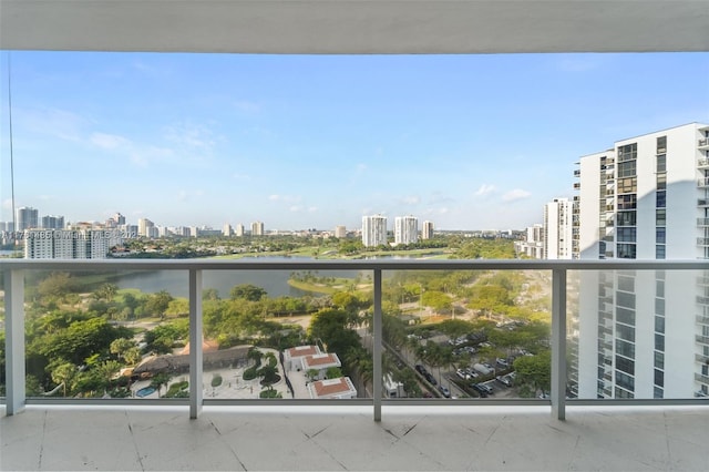 balcony featuring a water view and a city view