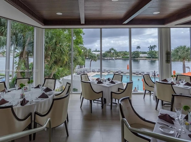 sunroom with beamed ceiling, wooden ceiling, and a water view