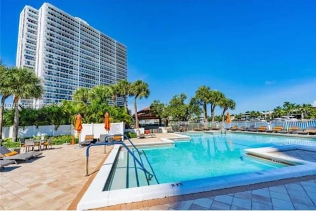 community pool featuring a patio and fence