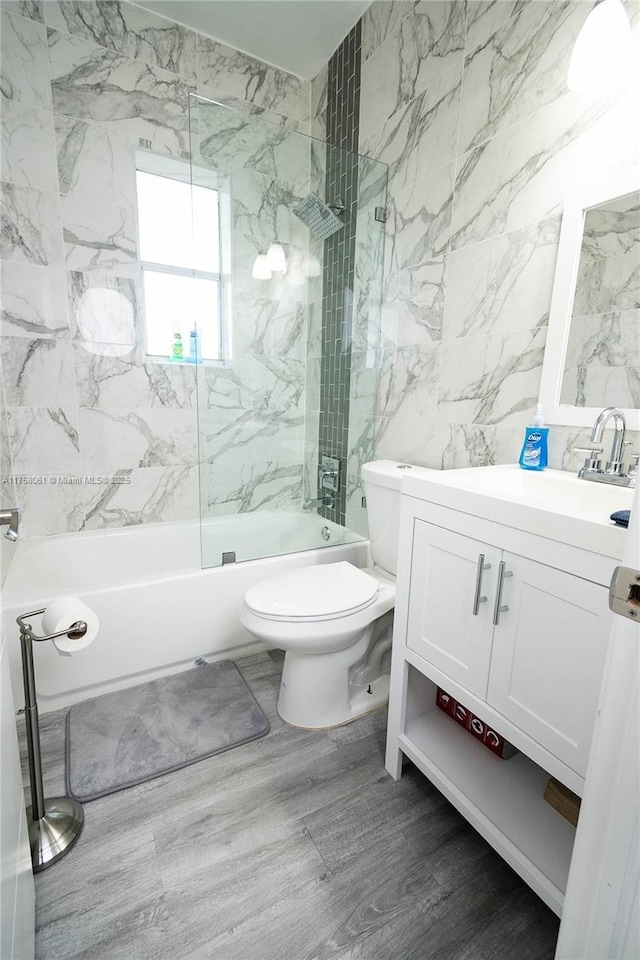 full bathroom featuring vanity, toilet, wood finished floors, and  shower combination