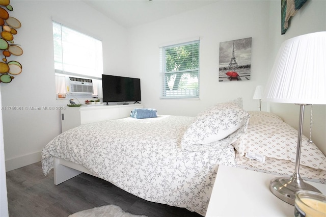 bedroom with cooling unit and wood finished floors