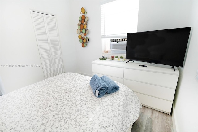 bedroom featuring a closet, cooling unit, and light wood finished floors