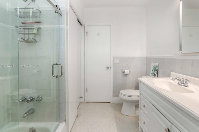 952 Hollywood Blvd, Hollywood, FL 33019 - bathroom with toilet, vanity, wainscoting, tile walls, and speckled floor