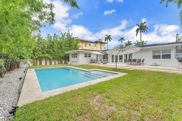 952 Hollywood Blvd, Hollywood, FL 33019 - rear view of property featuring a patio, a fenced in pool, a fenced backyard, stucco siding, and a lawn