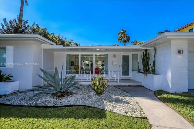 952 Hollywood Blvd, Hollywood, FL 33019 - property entrance featuring stucco siding, brick siding, and a porch