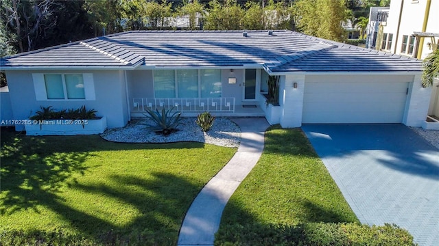 952 Hollywood Blvd, Hollywood, FL 33019 - single story home with driveway, a tile roof, covered porch, a front yard, and an attached garage