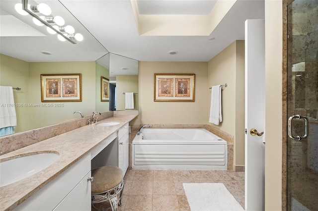 bathroom with double vanity, a shower stall, a garden tub, and a sink