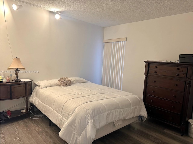 bedroom featuring a textured ceiling and dark wood-style flooring