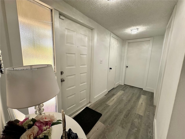 interior space with a textured ceiling and wood finished floors