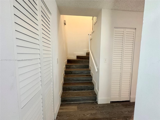 stairs featuring baseboards, a textured ceiling, and wood finished floors