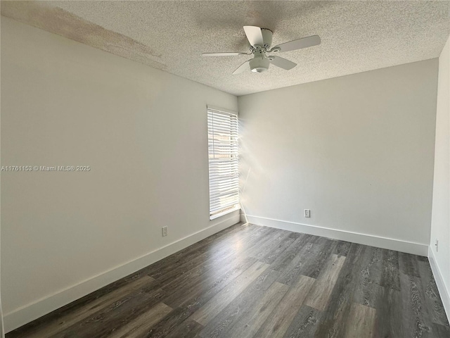 empty room featuring ceiling fan, baseboards, dark wood-style flooring, and a textured ceiling