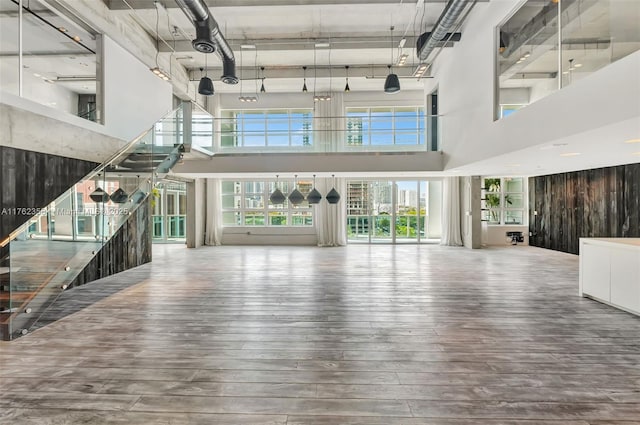 unfurnished living room with hardwood / wood-style flooring and a towering ceiling