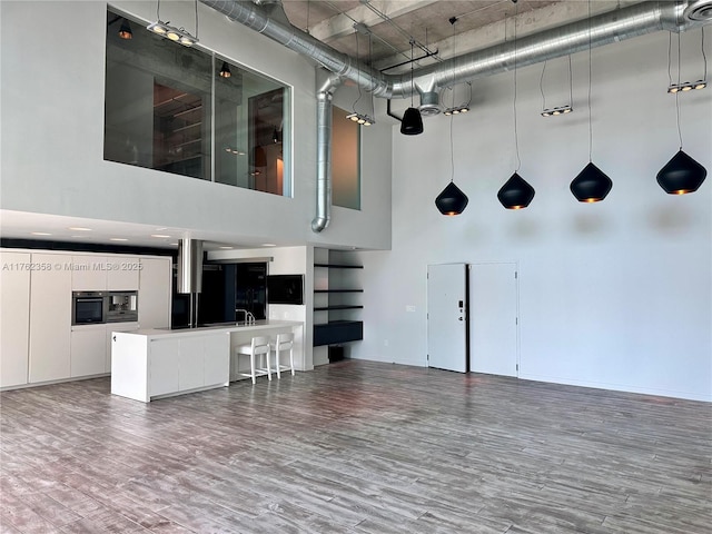 interior space with wood finished floors, a towering ceiling, and a sink