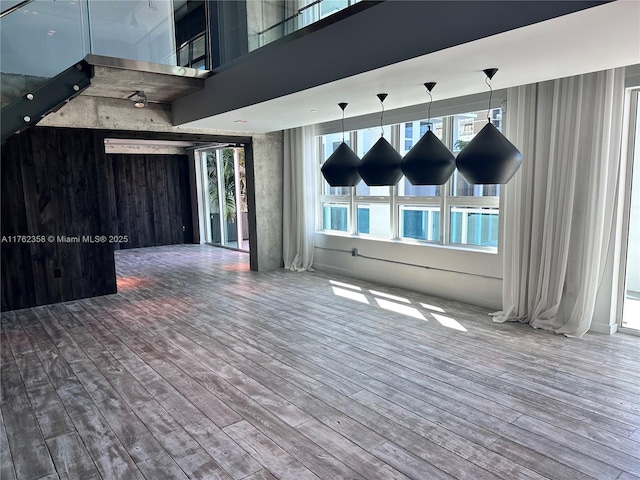 unfurnished room featuring wood finished floors and a towering ceiling