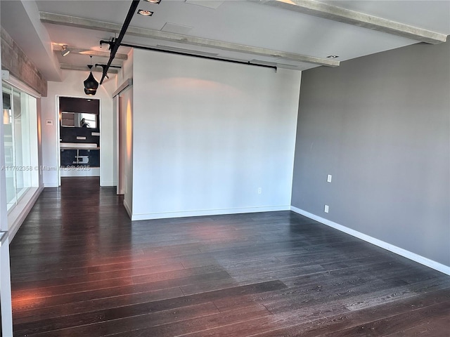 unfurnished room with baseboards and wood finished floors