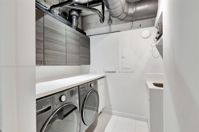 laundry room with light tile patterned flooring, baseboards, washer and clothes dryer, and cabinet space