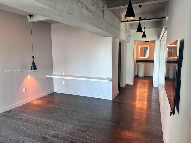 empty room featuring baseboards and wood finished floors