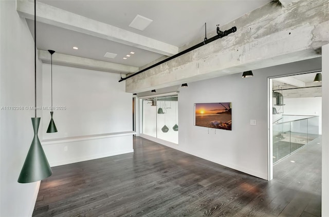 interior space with wood finished floors, beam ceiling, and baseboards