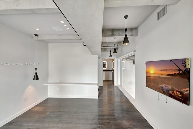 interior space with baseboards, wood finished floors, and visible vents