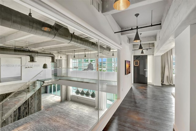 hall featuring wood-type flooring, plenty of natural light, and visible vents