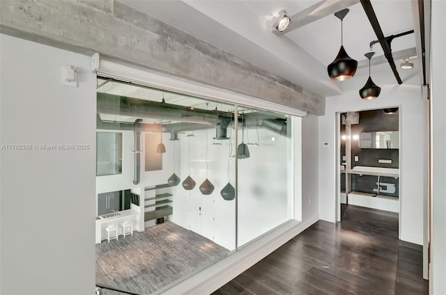 hallway with wood finished floors and beam ceiling