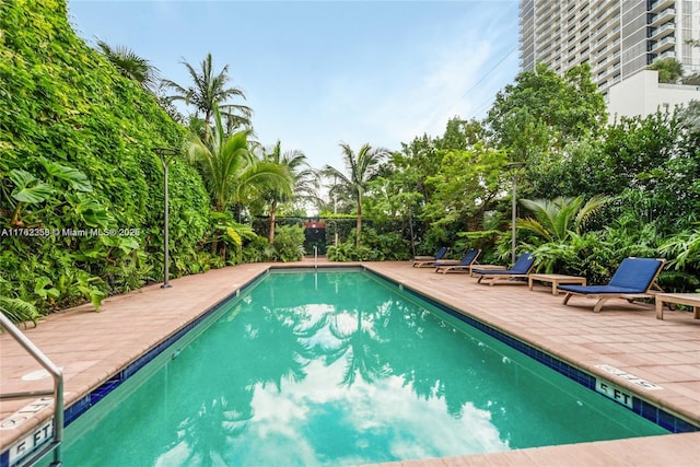 pool with a patio area and fence