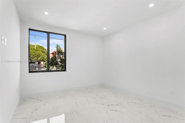 empty room featuring recessed lighting, baseboards, and marble finish floor