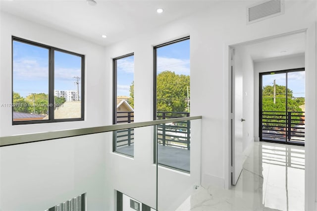 hall with recessed lighting, visible vents, marble finish floor, and a healthy amount of sunlight