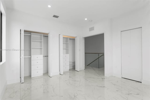 unfurnished bedroom with visible vents, recessed lighting, multiple closets, and marble finish floor