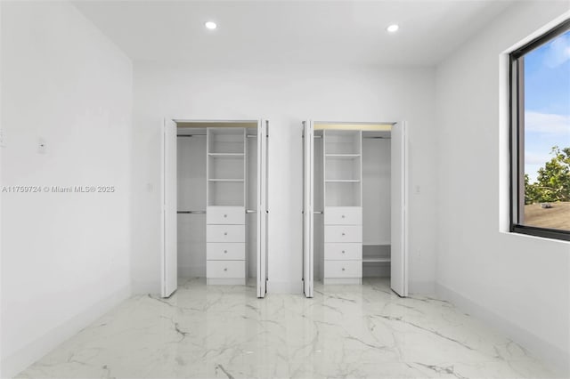 unfurnished bedroom featuring multiple windows, recessed lighting, and multiple closets