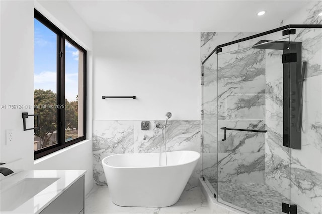 full bath with a marble finish shower, a freestanding tub, marble finish floor, and recessed lighting