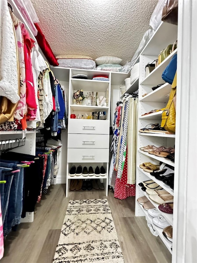 walk in closet with wood finished floors