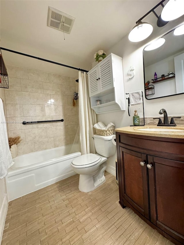 bathroom featuring visible vents, toilet, wood finished floors, shower / bath combination with curtain, and vanity