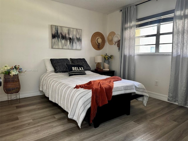 bedroom with wood finished floors and baseboards