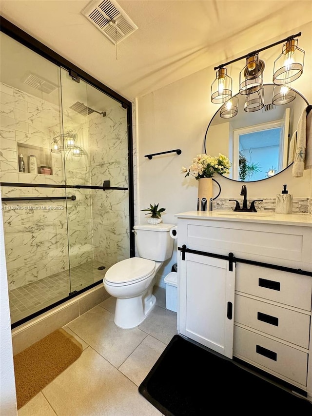 bathroom with visible vents, toilet, a shower stall, and vanity