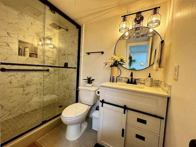 bathroom featuring toilet, a stall shower, vanity, and tile patterned flooring