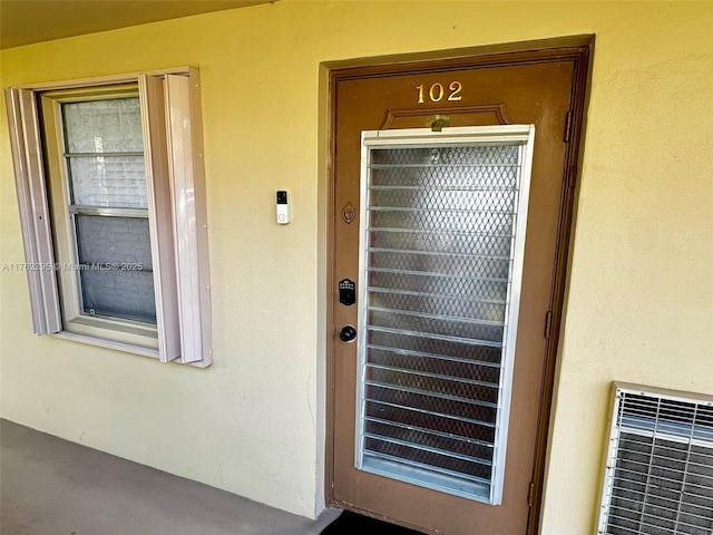 entrance to property with stucco siding