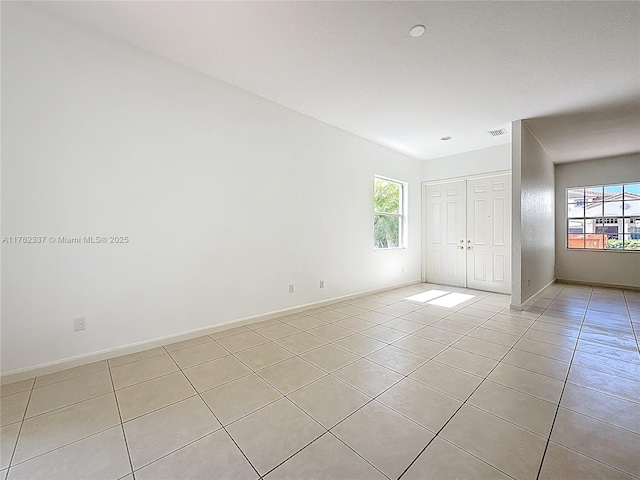 2217 SW Newport Isles Blvd, Port St Lucie, FL 34953 - spare room with light tile patterned flooring and plenty of natural light