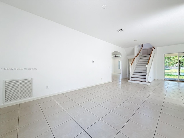 2217 SW Newport Isles Blvd, Port St Lucie, FL 34953 - empty room featuring light tile patterned floors, stairs, and arched walkways