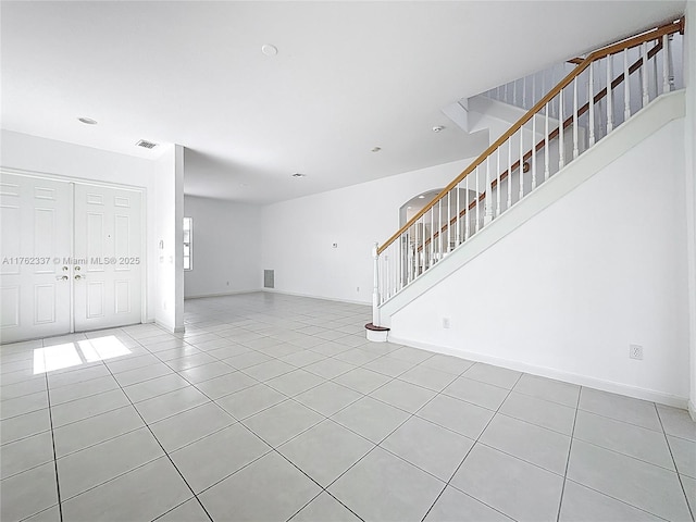 2217 SW Newport Isles Blvd, Port St Lucie, FL 34953 - unfurnished living room with stairway and light tile patterned flooring