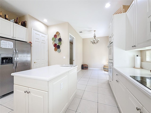 kitchen featuring white cabinetry, light tile patterned floors, stainless steel fridge, and a center island